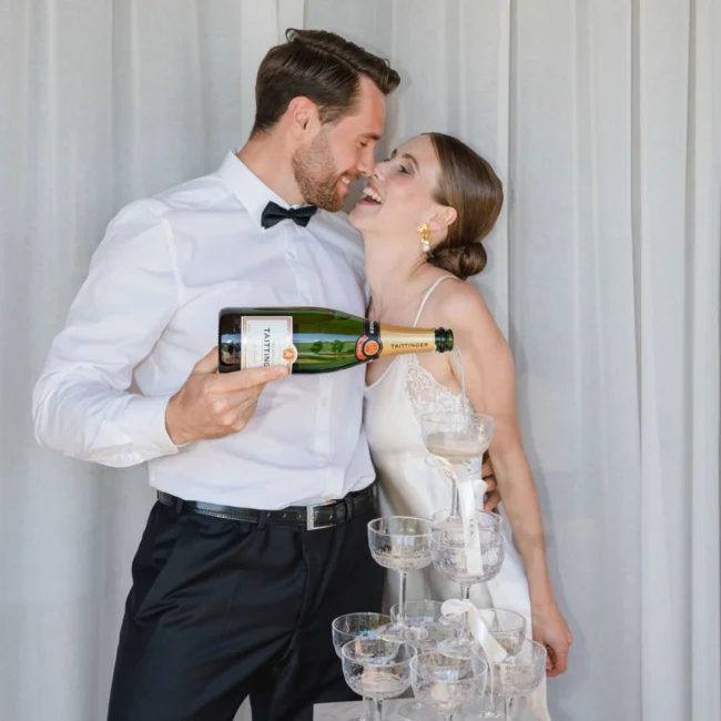 Brautpaar gießt Champagner in eine Gläserpyramide – Hochzeitsempfang