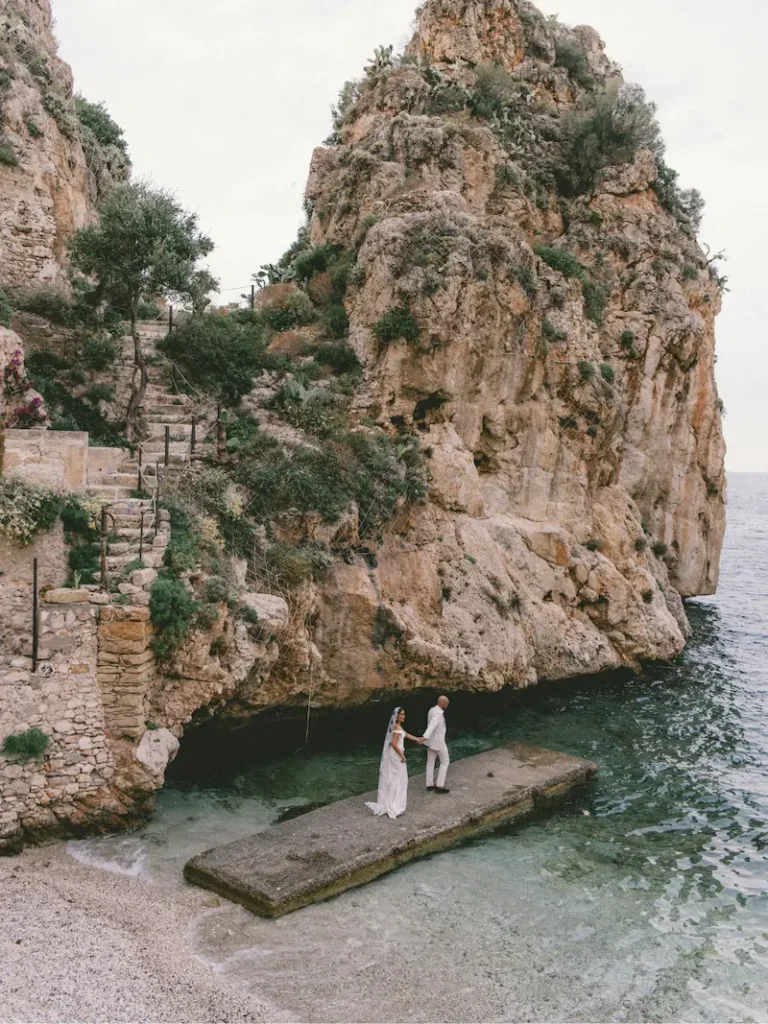Destination Wedding auf Mallorca – Brautpaar auf einem Steinsteg in einer Felsbucht